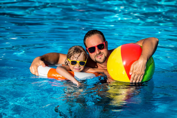 istock Child and father playing in swimming pool 980343000