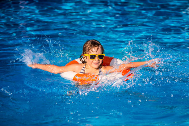 istock Child playing in swimming pool 980343008