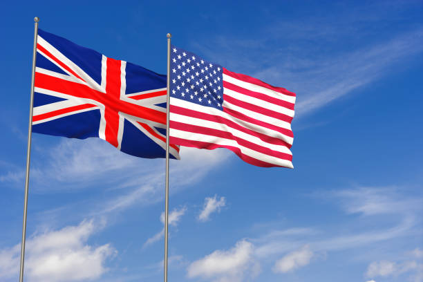 United Kingdom and USA flags over blue sky background stock photo