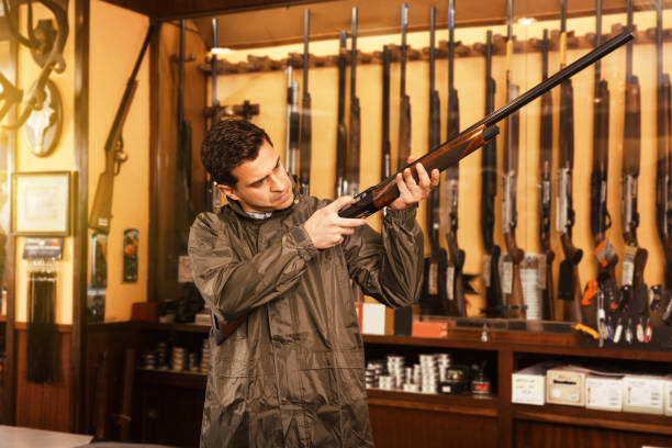 istock Man choosing rifle in shop 980353724