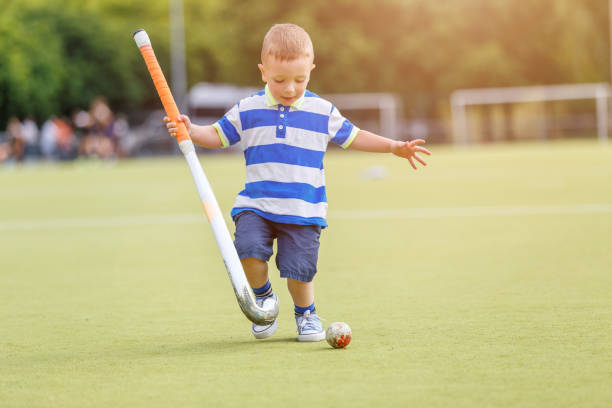 istock Small funny boy playing field hockey 980398436