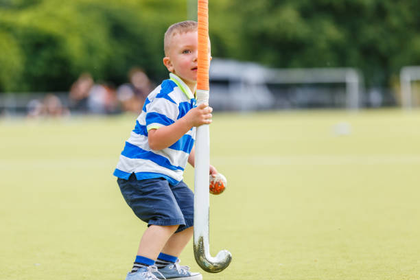 istock Small funny boy playing field hockey 980398448
