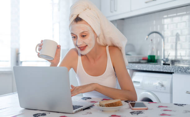 istock Woman with mask using laptop 980401008