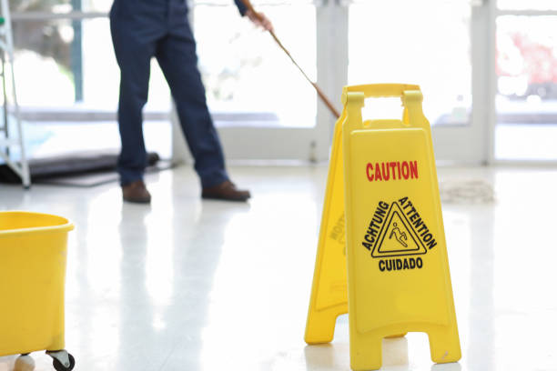 istock Unrecognizable male janitor mopping floor in office building. 980406202