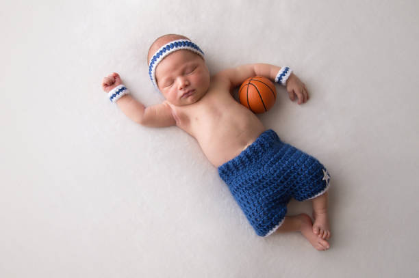 生まれたばかりの赤ちゃんの男の子バスケット ボールの衣装を着て - baby people headband portrait ストックフォトと画像