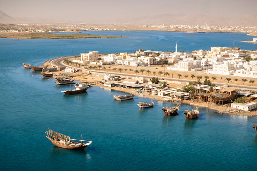 View looking out over Sur in Oman with traditional wooden Dhow ships.