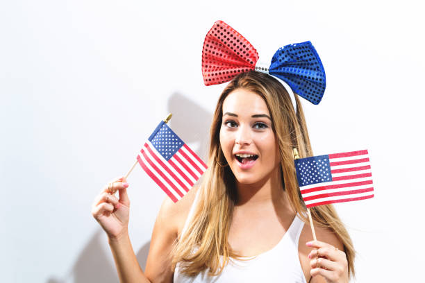 istock Happy young woman holding American flags 980427940