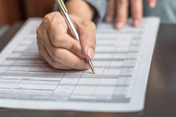 istock Administrator's hand fill in business schedule form document writing on yearly work plan, monthly timetable sheet, or weekly time table paper for office tasks, things and jobs to do list 980432346