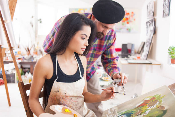 istock Fine art student working with teacher in atelier 980435836