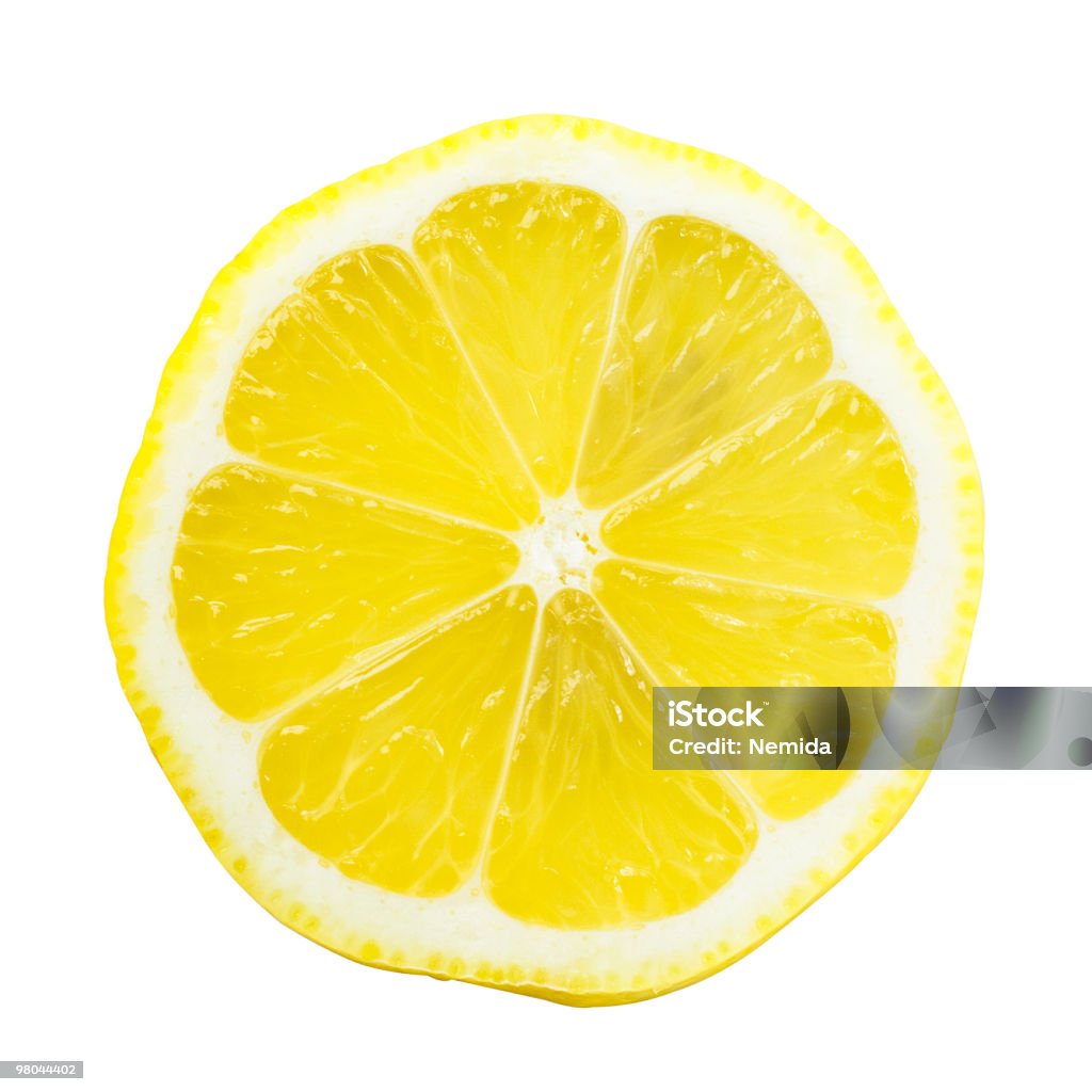 Lemon Slice Over White with a Bright Yellow Slice of lemon isolated on white background. The perspective of the image is top view while you can see the seeds through it. It is a bright and clear image with a beautiful yellow. Lemon - Fruit Stock Photo