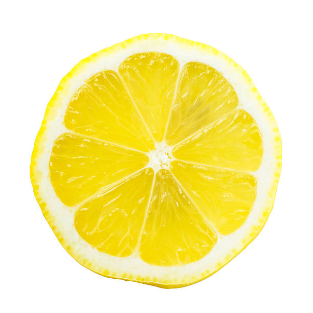 Lemon Slice Over White with a Bright Yellow Slice of lemon isolated on white background. The perspective of the image is top view while you can see the seeds through it. It is a bright and clear image with a beautiful yellow. slice of food stock pictures, royalty-free photos & images
