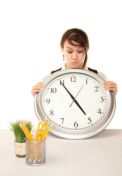 Woman at work holding large clock  clock wall clock face clock hand stock pictures, royalty-free photos & images