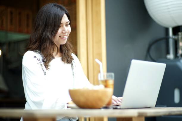 istock Woman working with a laptop at a bar 980458192