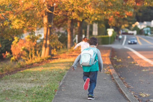 istock Elementary-age siblings running to school with their backpacks 980480290