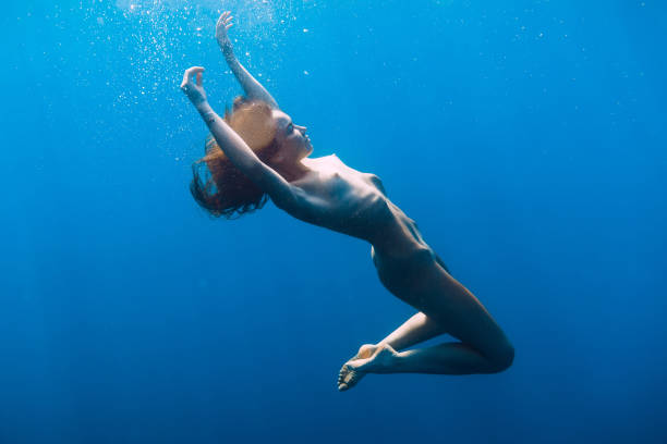 Naked young woman is underwater. Beautiful woman with naked body in sea Naked young woman is underwater. Beautiful woman with naked body in sea naked stock pictures, royalty-free photos & images
