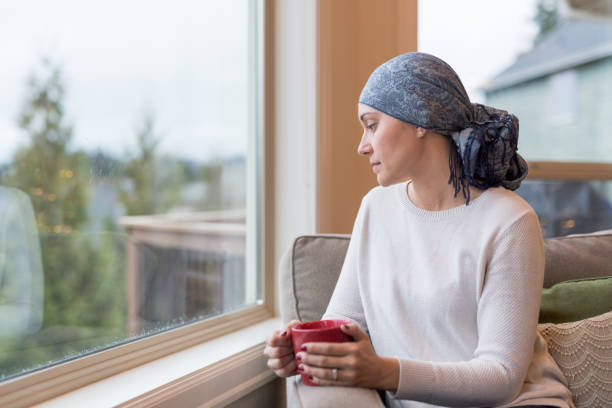 istock A middle-aged cancer survivor sits by the window and reflects on her life 980487724