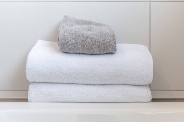 istock White and gray folded towels against white tiles in bathroom 980491764