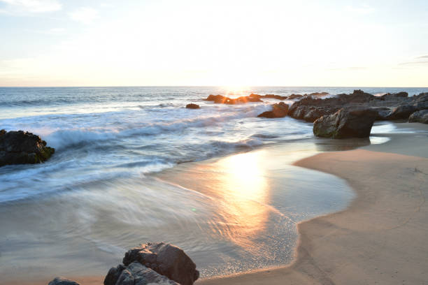 istock setting sun just on the horizon on Pacific coast beach in Baja, Mexico 980505688