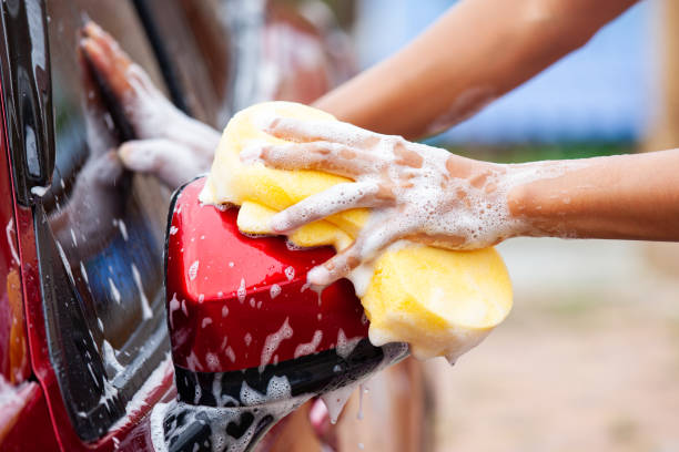 istock Man washing red car with sponge and soap 980515328