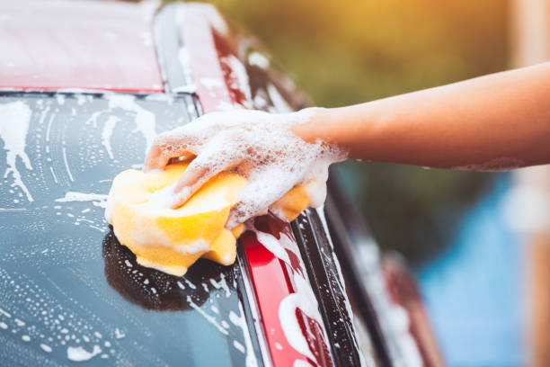 istock Man washing red car with sponge and soap 980515364