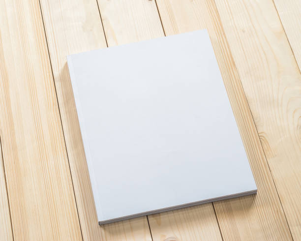 istock Blank book cover mockup template with page front side on white surface on wood table 980516002