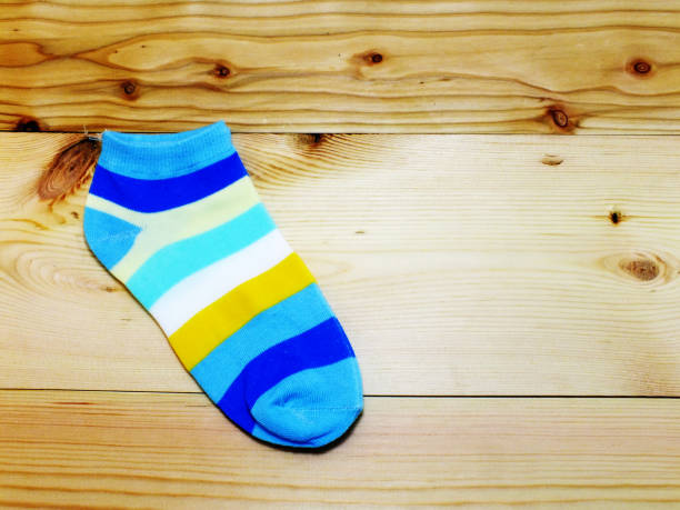 istock blue white and yellow color strips sock with space on wooden background 980539840
