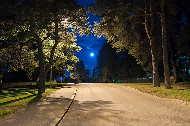 Full moon over quite village at night. Beautiful night landscape of old town street with lights