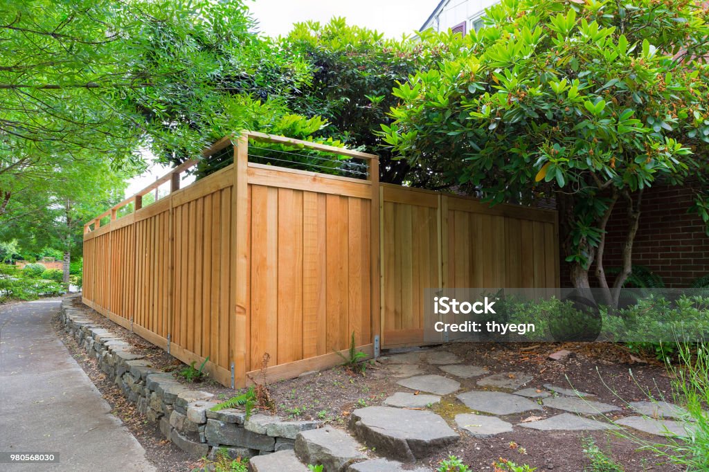 New Cedar Wood Fence around house side yard landscaping New Cedar Wood Fence with gate door on home side yard landscaping Fence Stock Photo