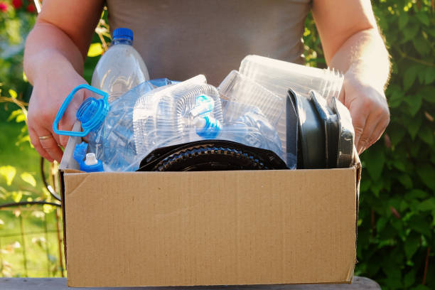 istock Man's hands holding a carton with plastic garbage for recycling. Recycle concept 980601354
