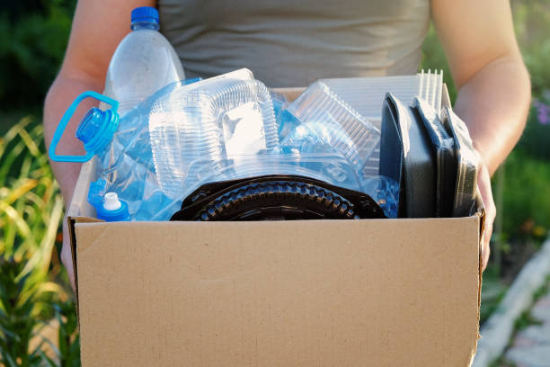 istock Man's hands holding a carton with plastic garbage for recycling. Recycle concept 980601396