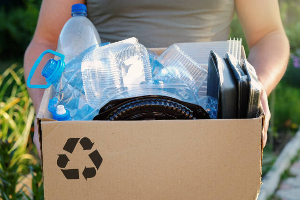 istock Man's hands holding a carton with plastic garbage for recycling. Recycle concept 980601428