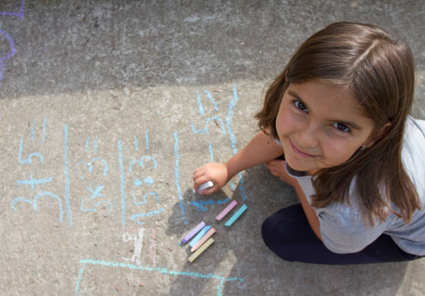 여자 꼬마 생각, 쓰기와 포장도 색된 초와 수학 방정식에 계산. 학교 및 휴가 개념입니다. 교육 개념입니다. - little girls sidewalk child chalk 뉴스 사진 이미지