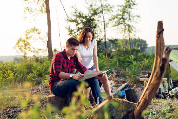 istock Couple hikers in the mountains, they is looking at map 980632930