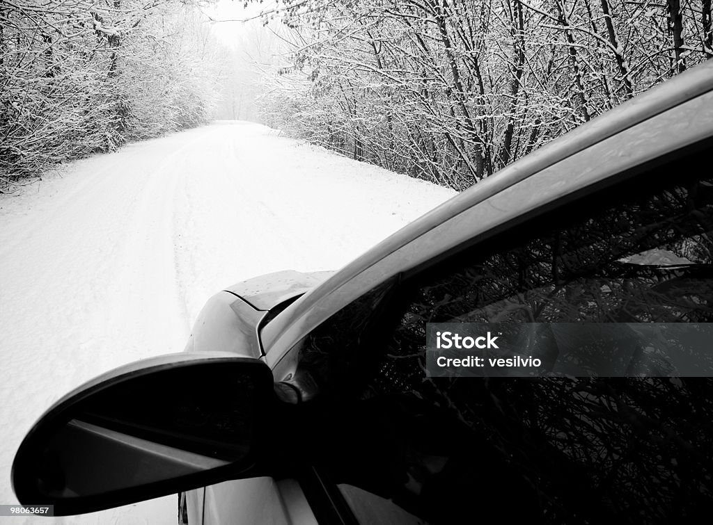 Winter drive Rural empty road covered in snow, viewed from outside a car window. Bare Tree Stock Photo