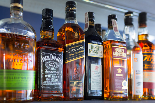 Gdansk, Poland - May 24, 2018: Selection of whiskey bottles on the bar shelf. Selective focus on the Johnnie Walker Black Label bottle.