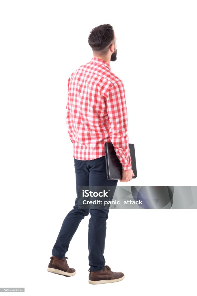 Back view of smart casual man with laptop walking and looking up watching copyspace Back view of smart casual man with laptop walking and looking up watching copyspace. Full length isolated on white background. People Stock Photo