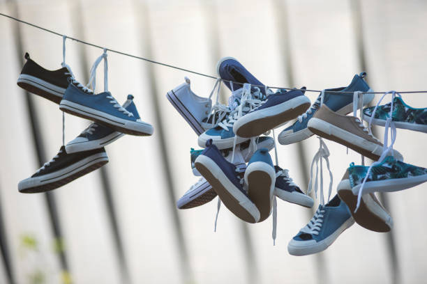 istock Pairs of sneakers hanging on cable 980646654