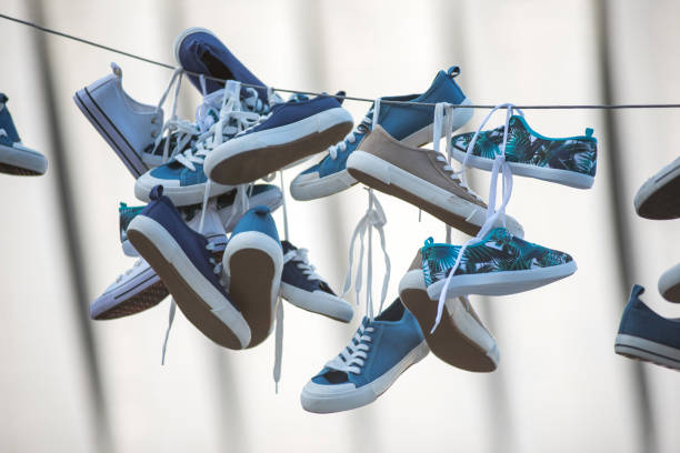 istock Pairs of sneakers hanging on cable 980646670