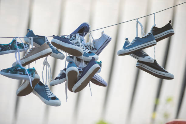 istock Pairs of sneakers hanging on cable 980646716