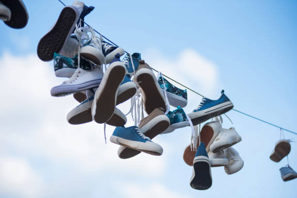 istock Pairs of sneakers hanging on cable 980646722