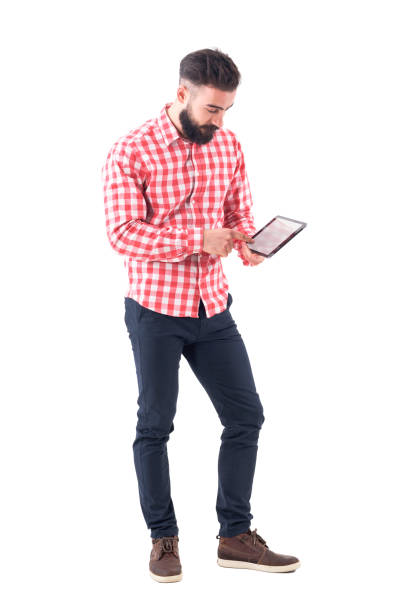 istock Young bearded stylish business man using tablet touch screen with finger. 980646932