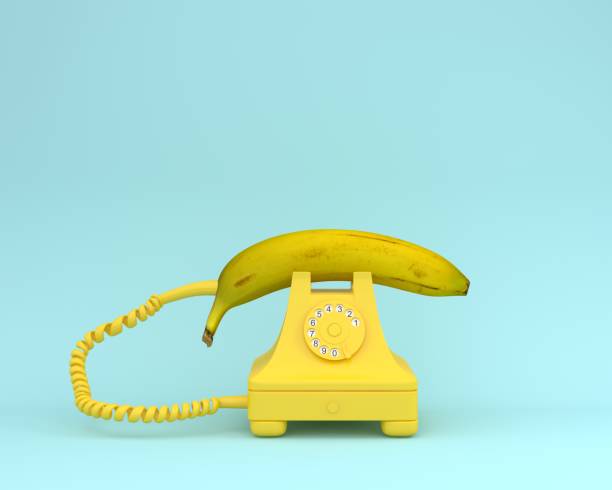 plátano fresco de la diseño idea creativa con teléfono retro amarillo sobre fondo azulado.  concepto mínimo de fruta. - b4 fotografías e imágenes de stock