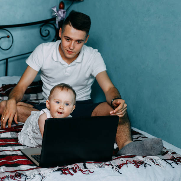 istock Curious baby girl using laptop sitting at home bed 980655456