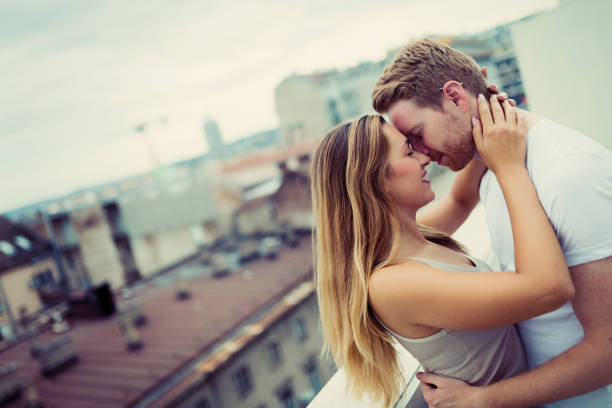 istock Romantic couple kissing on rooftop 980664930