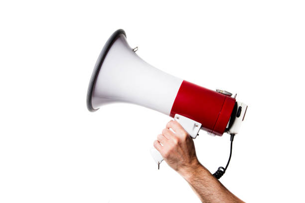 isolated portrait of a hand holding a megaphone side view of a hand holding a megaphone isolated on white background raised fist photos stock pictures, royalty-free photos & images