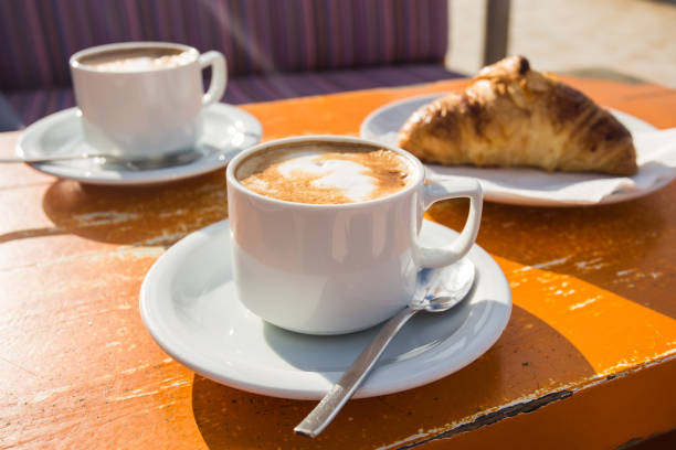 istock Two cups of invigorating cappuccino and a croissant for breakfast 980677262