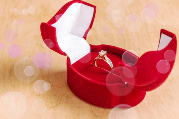 istock Engagement ring in a gift box on wooden background. 980677388