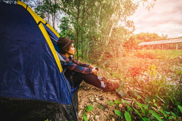 istock One man sitting outside the tent.  camping in forest. 980677526