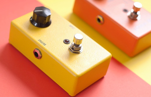 Yellow and orange guitar stompboxes on colorful background