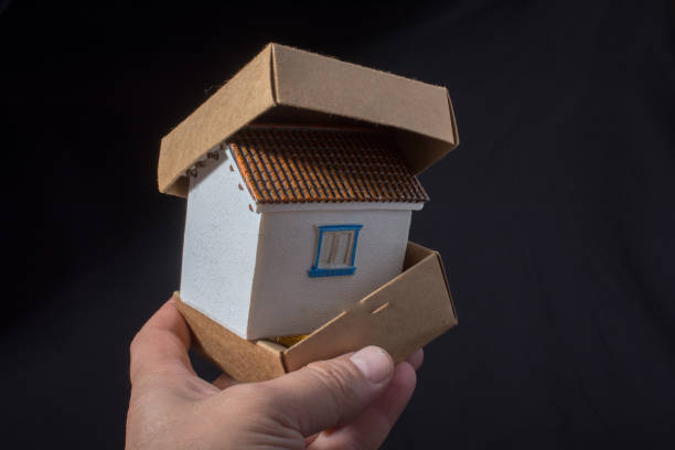 istock Little model house in hand in a box 980702592